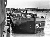 406430 Afbeelding van de rijnaak La Péniche langs een kade in Amsterdam. In het laadruim van het schip zal een ...